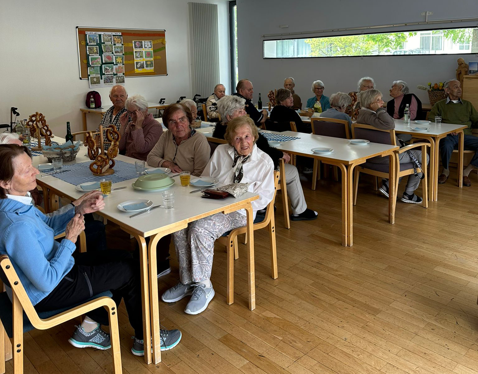 Die Seniorinnen und Senioren sitzen bei Maibowle zusammen. 